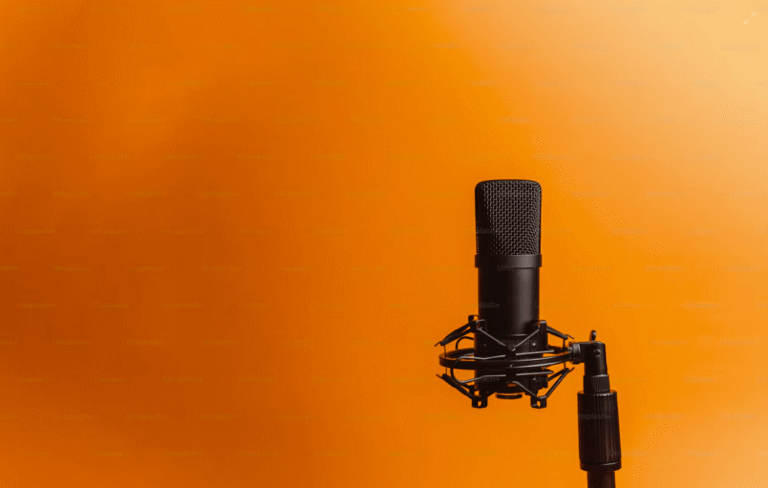 A black studio microphone on a stand against an orange background.