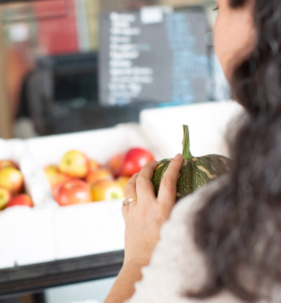 A person holding fresh produce at the market.