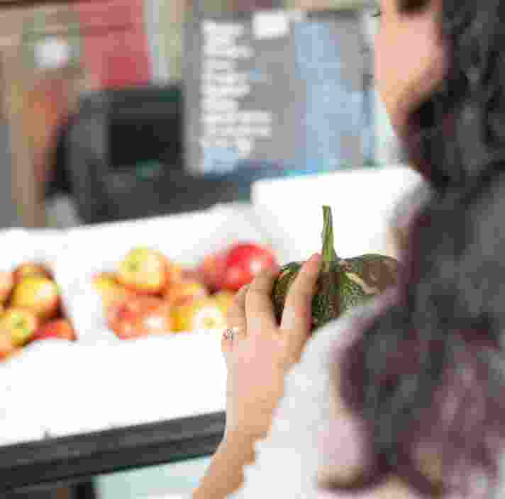 A person holding fresh produce at the market.