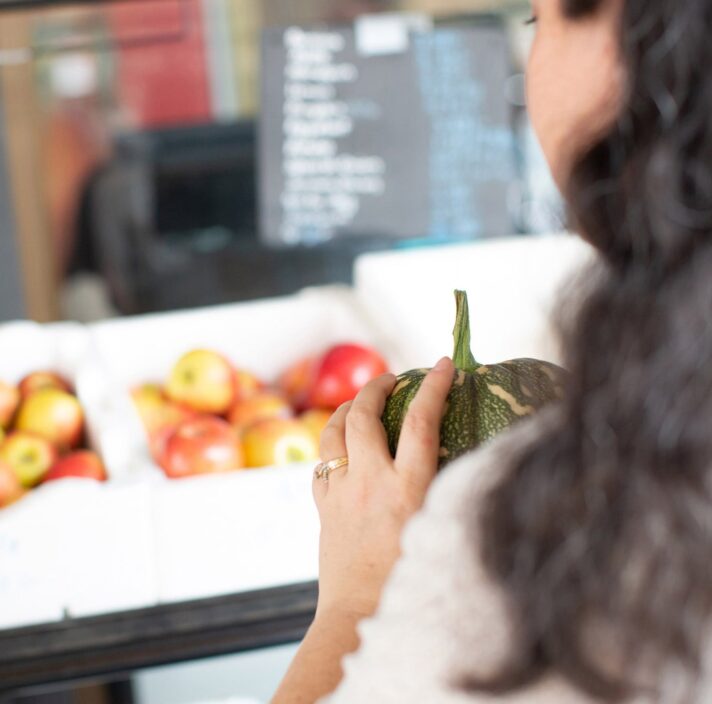 A person holding fresh produce at the market.