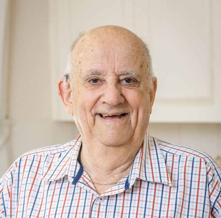 An older adult smiling straight at the camera.