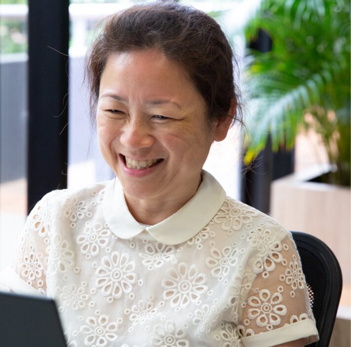 A person sitting at a table smiling.