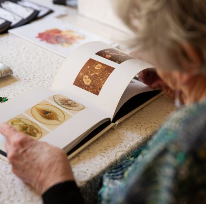 A person looking at the book. The image is taken over the shoulder of the person.