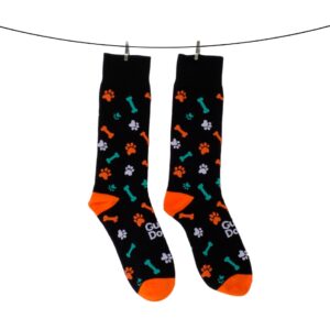 Two socks in black with orange toes and heels, showcasing a design of paws and bones, suspended on a line with clips.