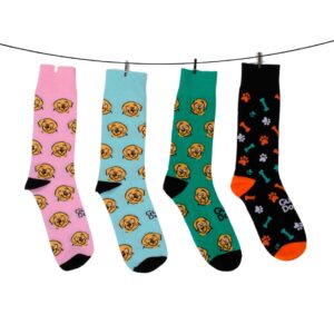 Four vibrant socks featuring cartoon dog faces and paw prints are hanging from a line.