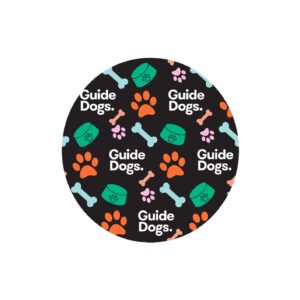 Circular design featuring the text "Guide Dogs" adorned with orange paw prints, pink and blue bones, and green bowls against a black background, inspired by the Dog Lead - Black product.