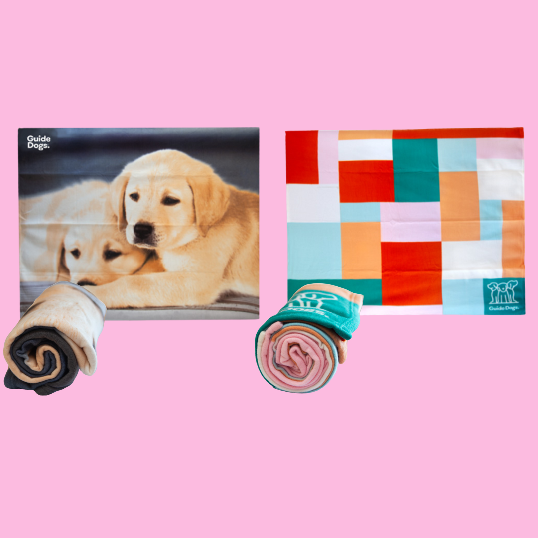 Two Polar Fleece Rugs on a pink background: the left one showcases two puppies, and the right displays a colorful geometric pattern. Both are rolled up in front of their designs.