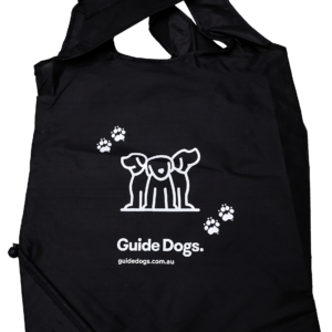 Black foldable bag featuring a white logo with three dogs and paw prints. The text reads "Guide Dogs" and "guidedogs.com.au.
