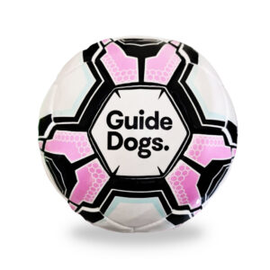 An Audible Soccer Ball featuring a black, white, and pink geometric pattern with the words Guide Dogs in the center.