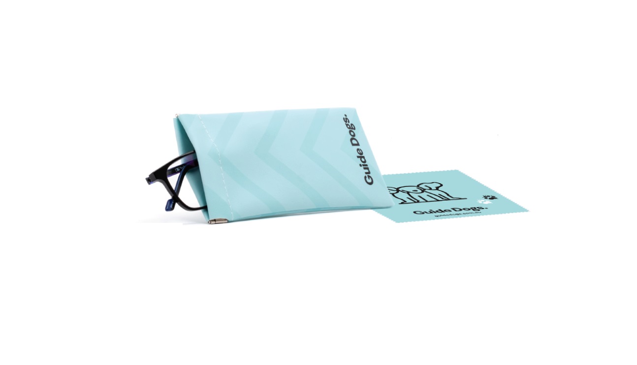 A turquoise Glasses Pouch with glasses partially inside, featuring the Guide Dogs text and logo. A matching lens cleaning cloth with the same logo is placed beside it.