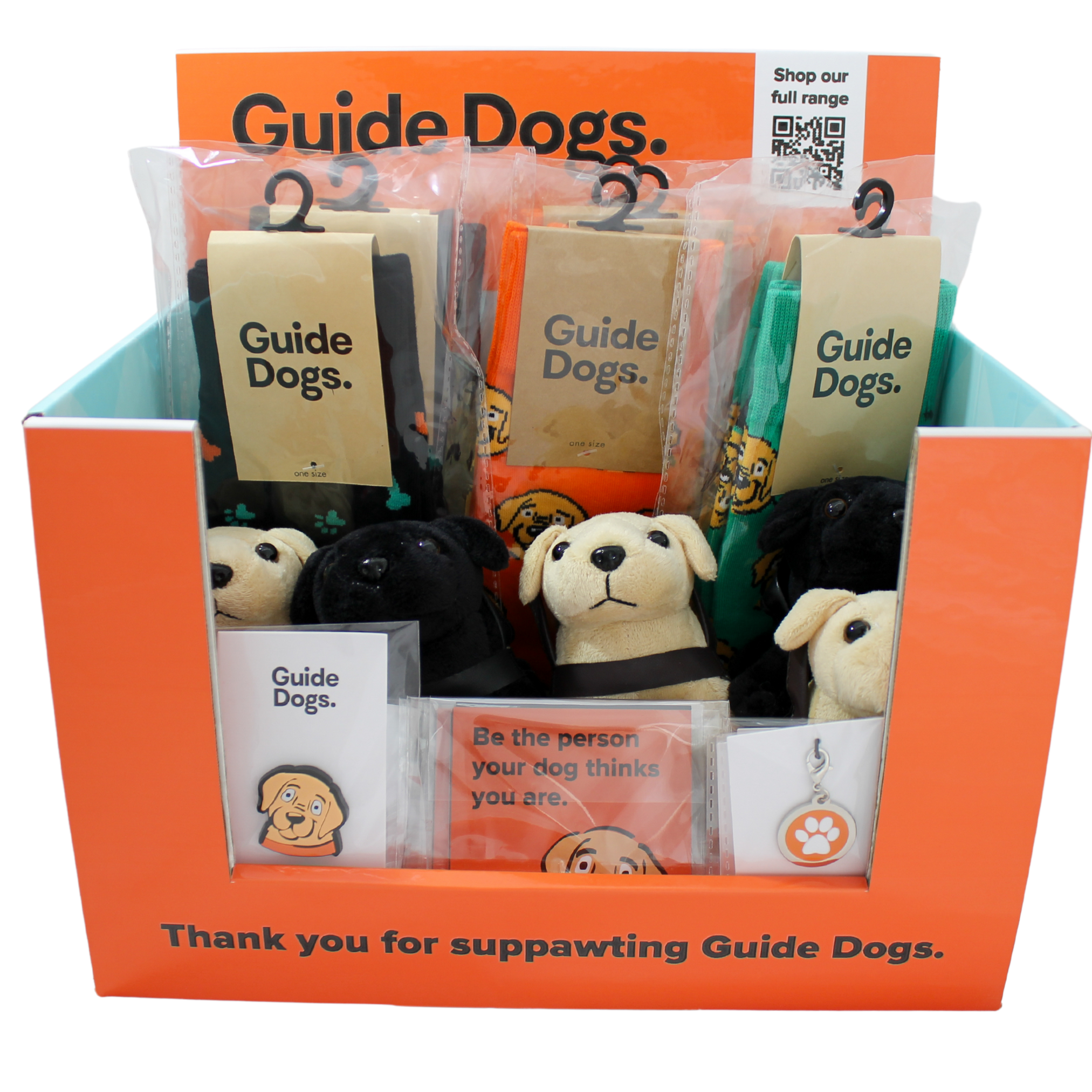 Display box contains Guide Dogs Fundraising Pack with plush guide dog toys, shoe charms, paw print charms, socks and magnets. Sign reads, Thank you for suppawting Guide Dogs.