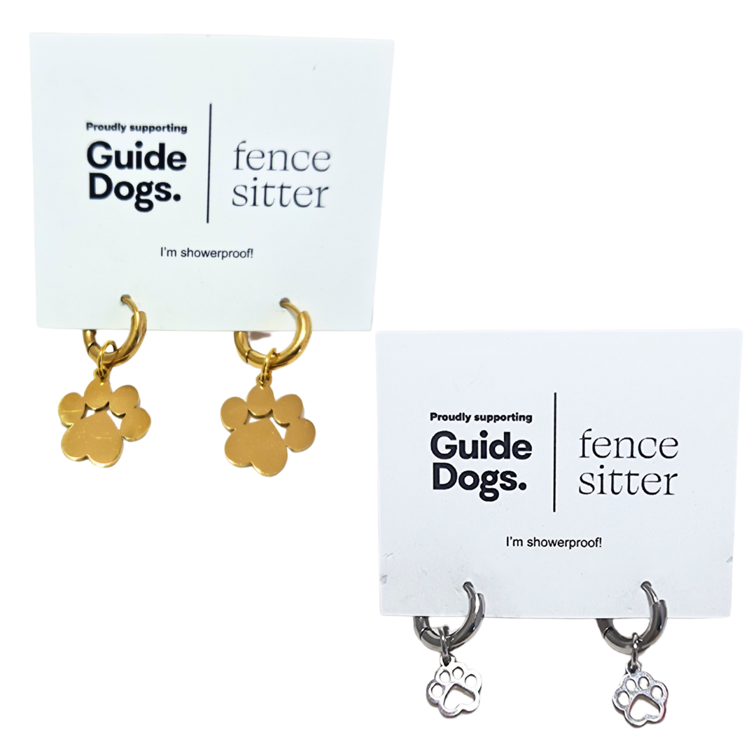 Two sets of Earrings - Huggie Paws featuring paw print charms, one gold and one silver, are displayed on cards with Guide Dogs and fence sitter logos.
