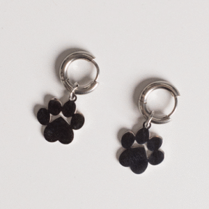 Earrings - Huggie Paws: Silver hoop earrings with dangling metal paw print charms displayed on a white background.