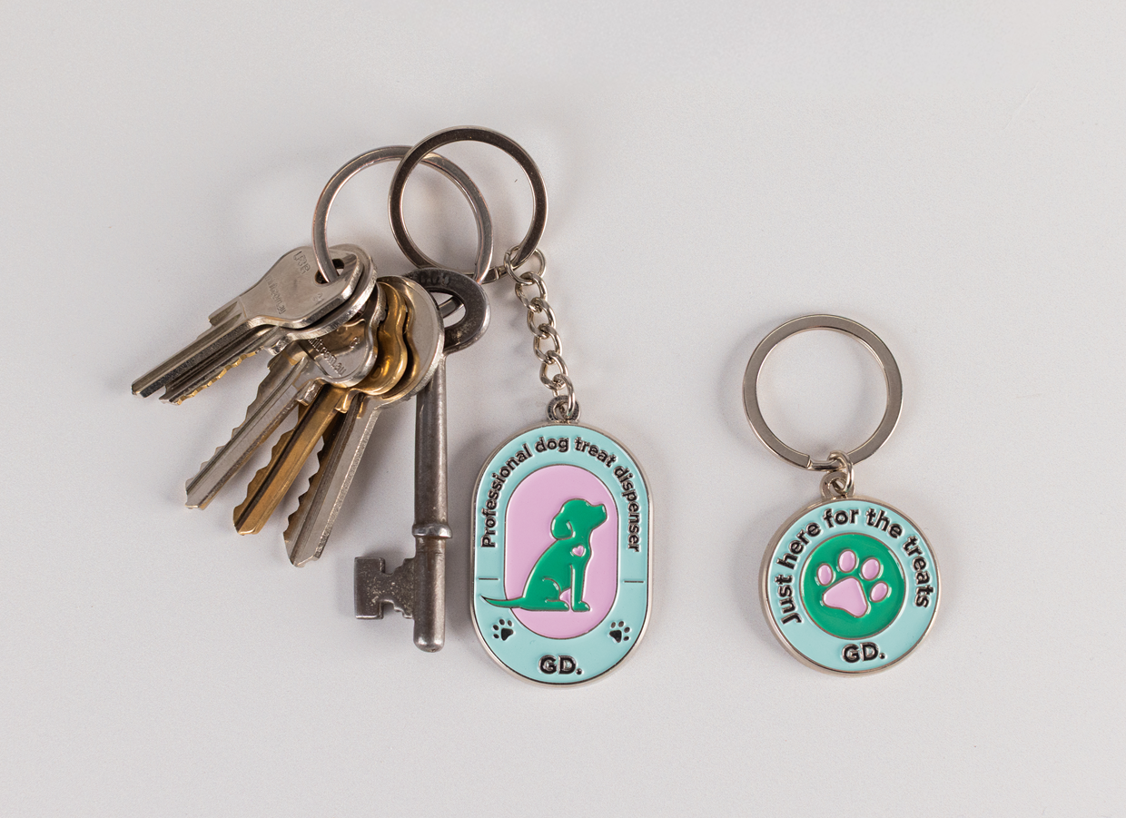 A set of keys with the Keyring and Charm Set featuring a professional dog treat dispenser keychain and a separate "Just here for the treats" charm with a paw print.