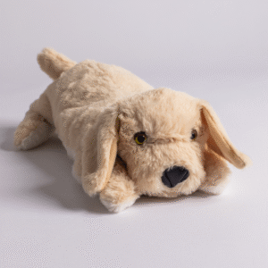 The Plush PJ Puppy, a beige plush toy dog, lies on a white surface with its front paws extended and facing forward.