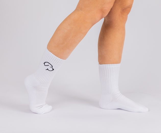 Model wearing Crew Socks - White, featuring a simple black outlined design on the side, standing against a white background.