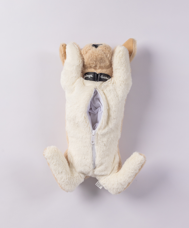 The Plush PJ Puppy is a soft dog toy lying on its back with an open belly zipper, showing its white inner lining.