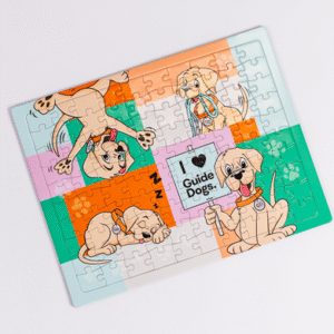 A completed Jigsaw Puzzle features cartoon guide dogs, one holding an I love Guide Dogs sign, set against a background of colorful blocks.