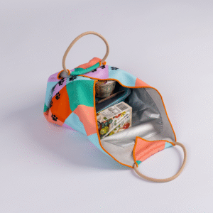 Open Lunch Bag with geometric and paw print design, holding a small food container and a juice box, displayed on a white background.
