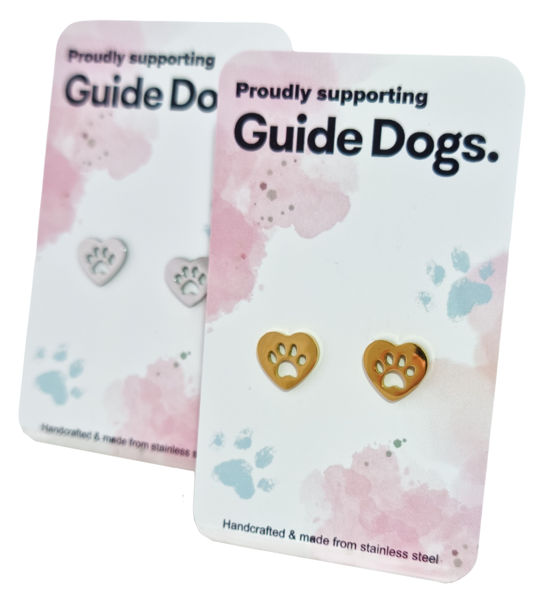 Two pairs of Earrings - Heart, one gold and one silver, featuring paw prints, displayed on Proudly supporting Guide Dogs cards with pastel paw print designs.