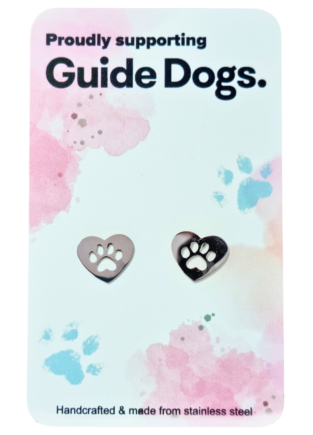 A pair of Heart earrings made from stainless steel with paw print cutouts, presented on a card stating “Proudly supporting Guide Dogs.”.