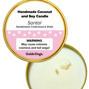 Top view of the Candle Tin - Gold, a handmade coconut and soy candle featuring a paw-shaped wax detail at the center, a lid labeled “Santal” scent, and a warning about extreme cosiness.